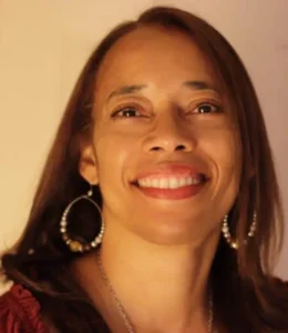 Smiling woman with long hair and earrings.